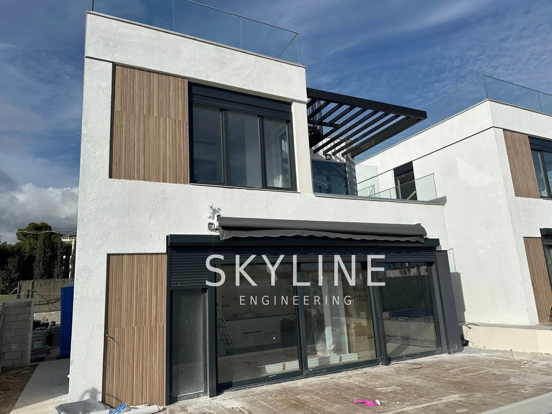 Completed two-storey facade of a Lanucia 6 villa in La Nucía with wood-slat cladding and roof terrace